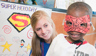 Volunteen Kara Skjoldager admires Chester Norsworthy's Spider-man mask and personalized cape.