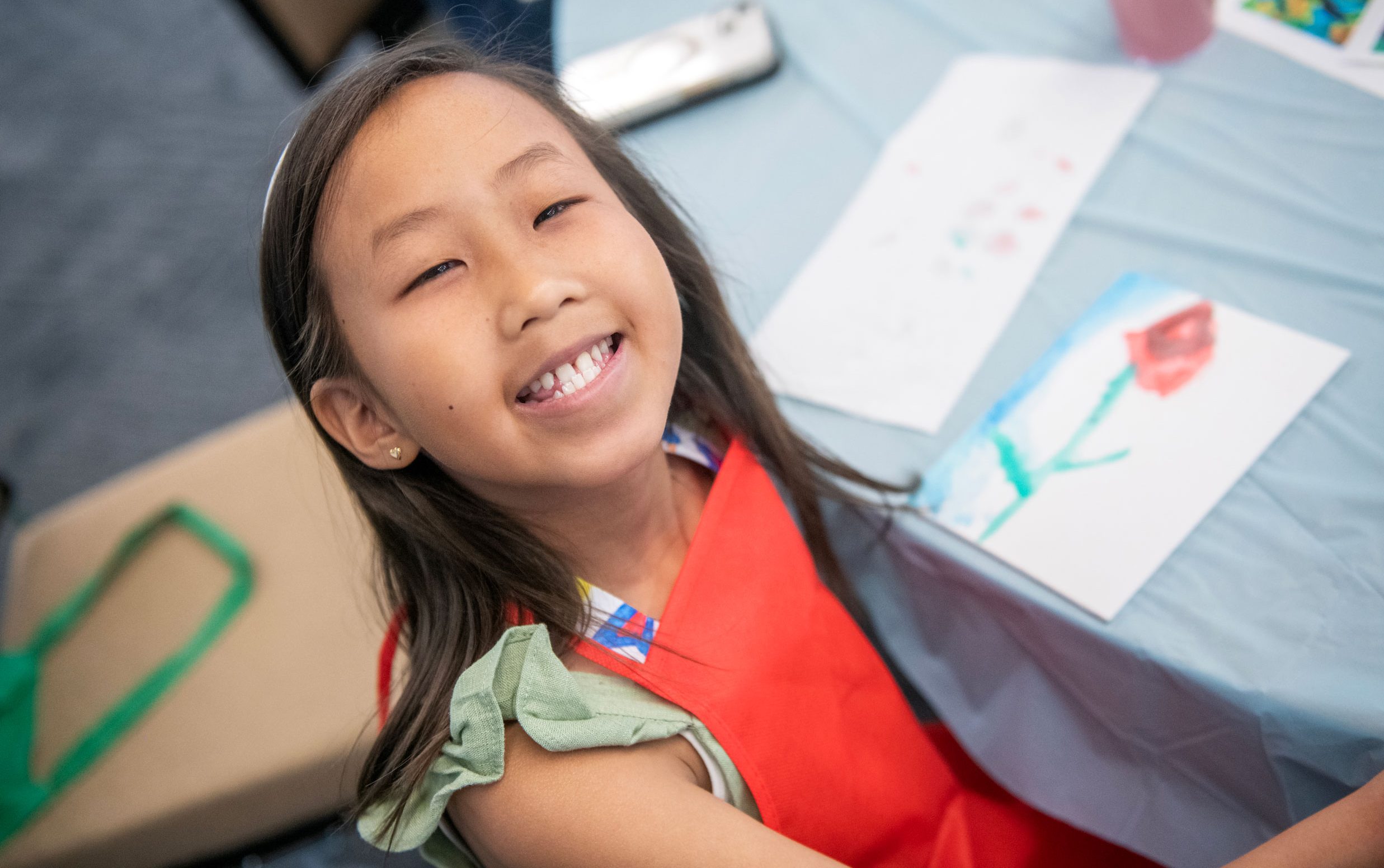 Patient Maelin-Kate smiles while painting a flower.