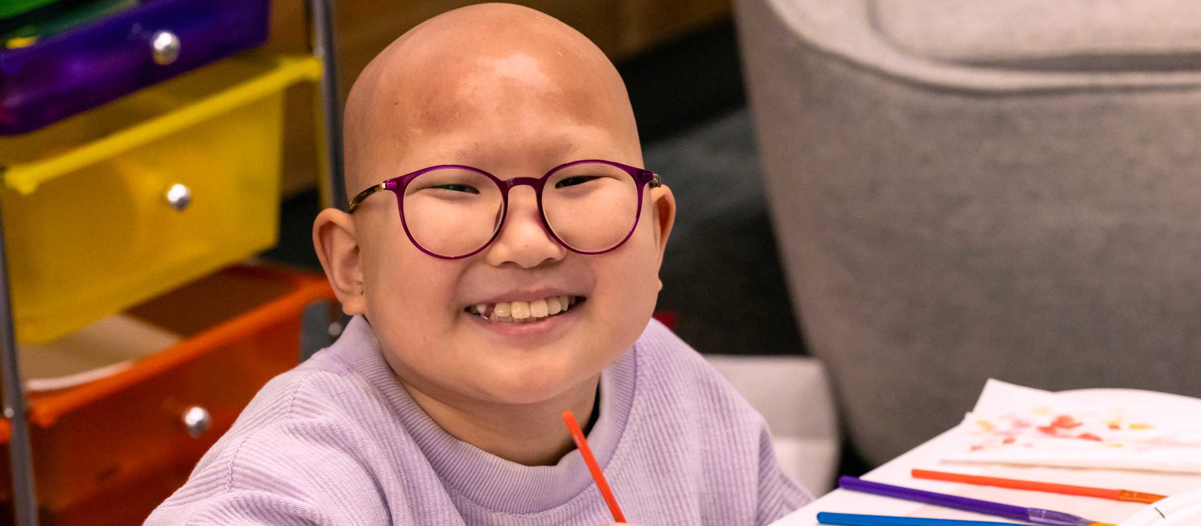 Patient Misheel sits with a broad smile and paints.