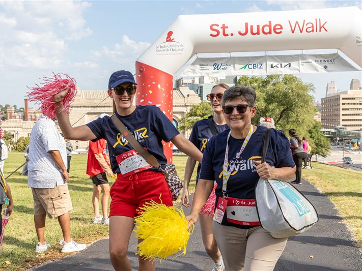 Participants of a St. Jude walk cross the finish line.