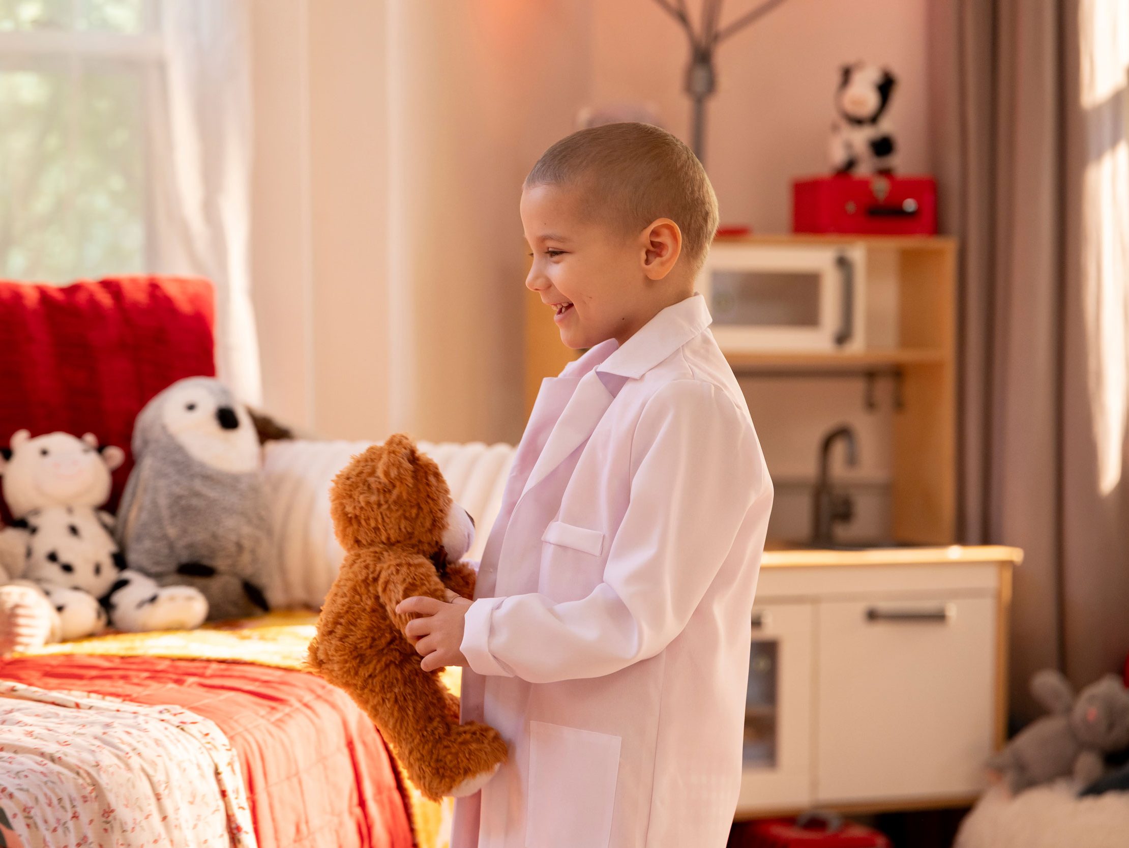 St. Jude patient Erma in a child's room holding a stuffed toy