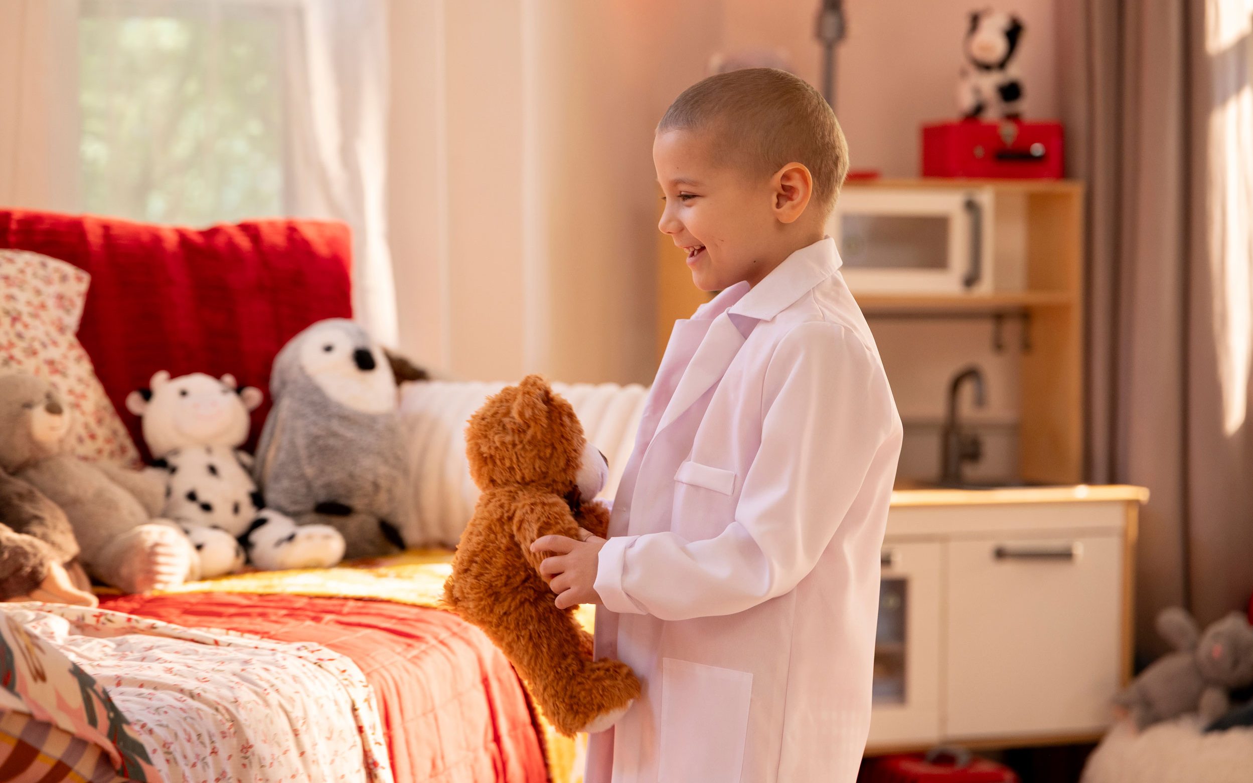 St. Jude patient Erma in a child's room holding a stuffed toy