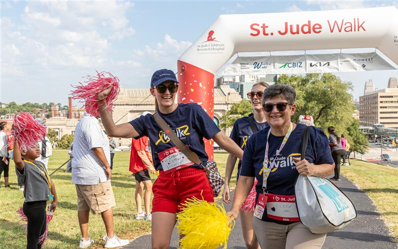Participants of a St. Jude walk cross the finish line.