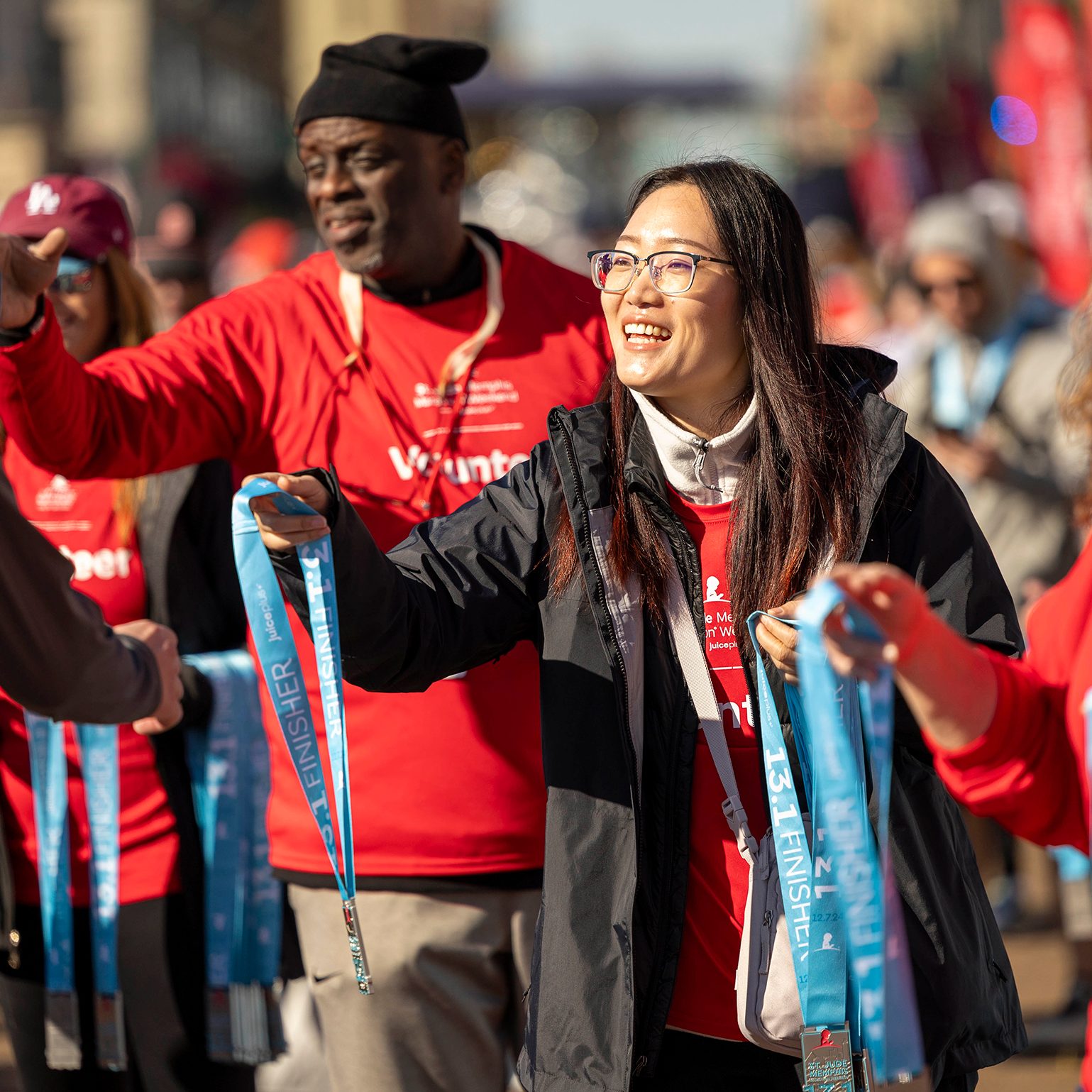 A volunteer hands out finisher medals at the St. Jude Memphis Marathon Weekend.