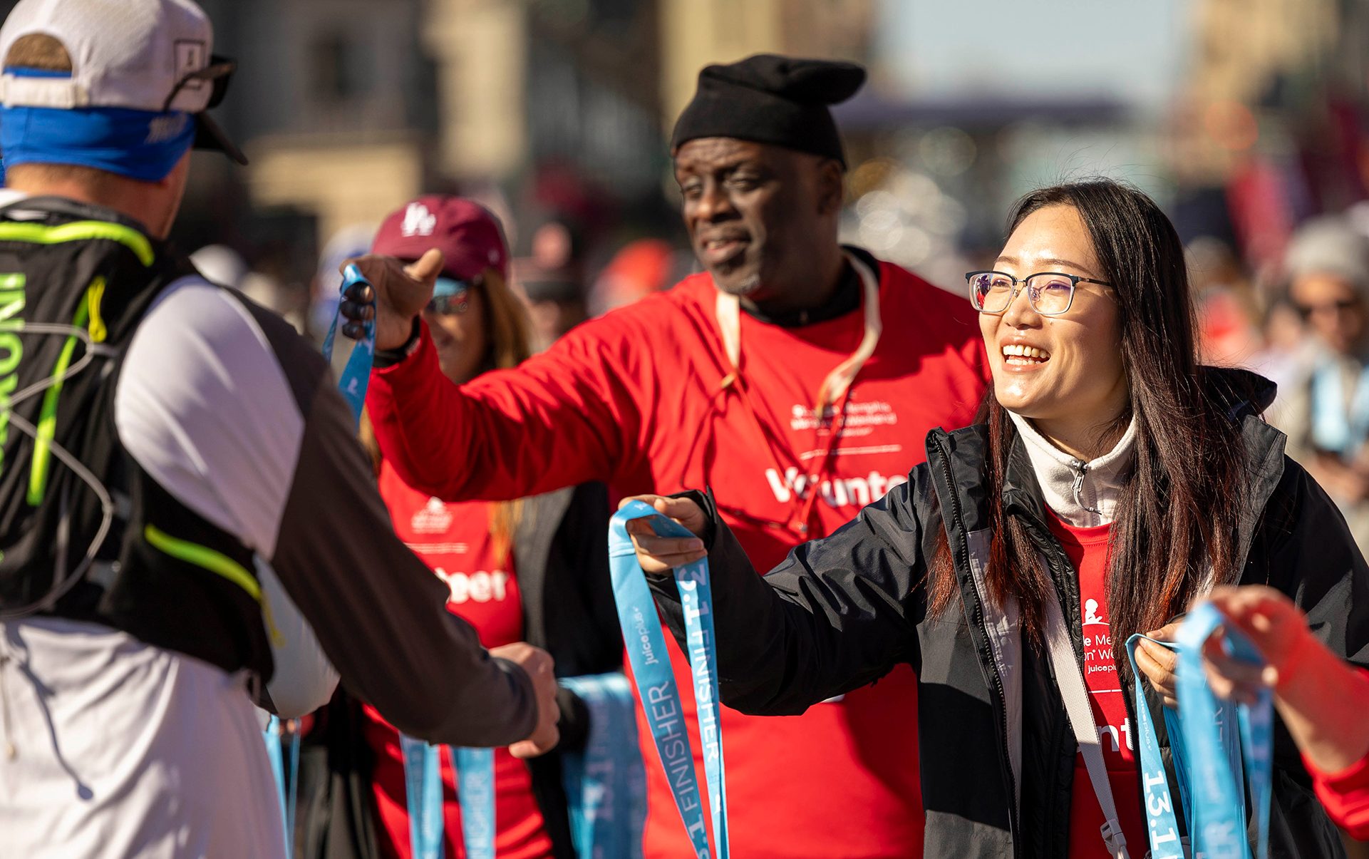 A volunteer hands out finisher medals at the St. Jude Memphis Marathon Weekend.