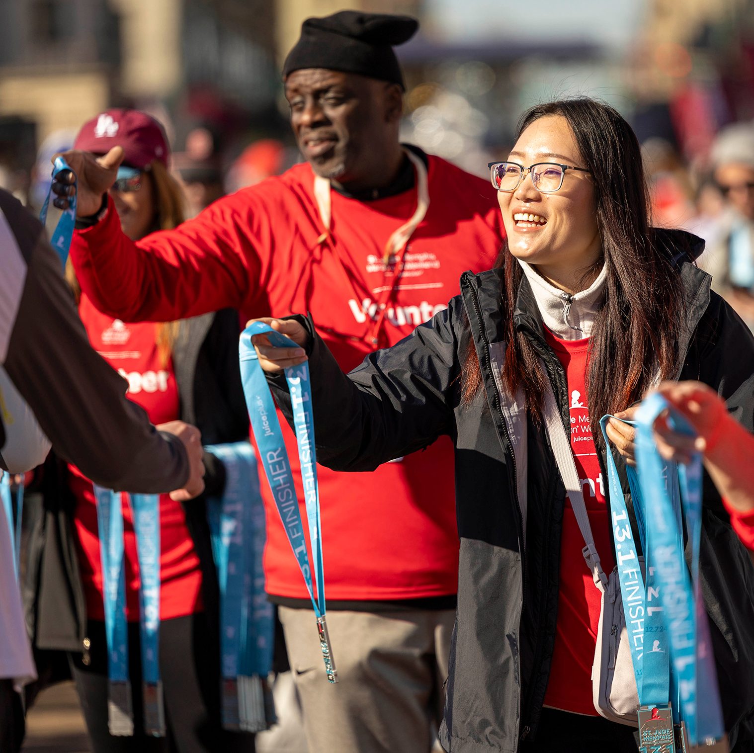 A volunteer hands out finisher medals at the St. Jude Memphis Marathon Weekend.