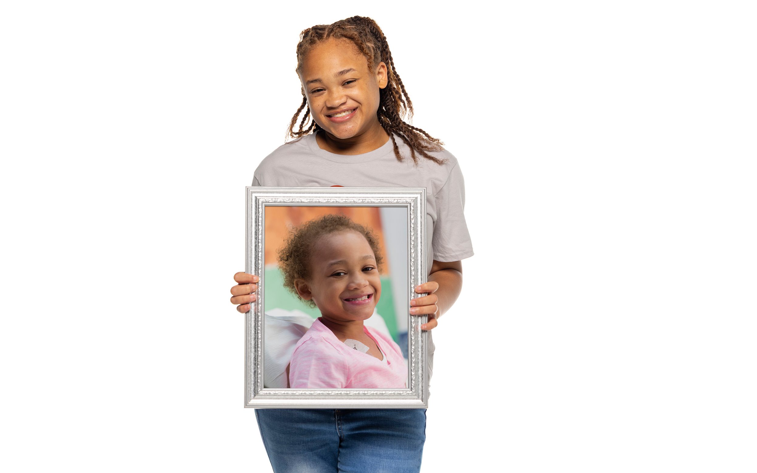 St. Jude survivor Marleigh holds a framed photo of herself from when she was undergoing treatment at St. Jude.