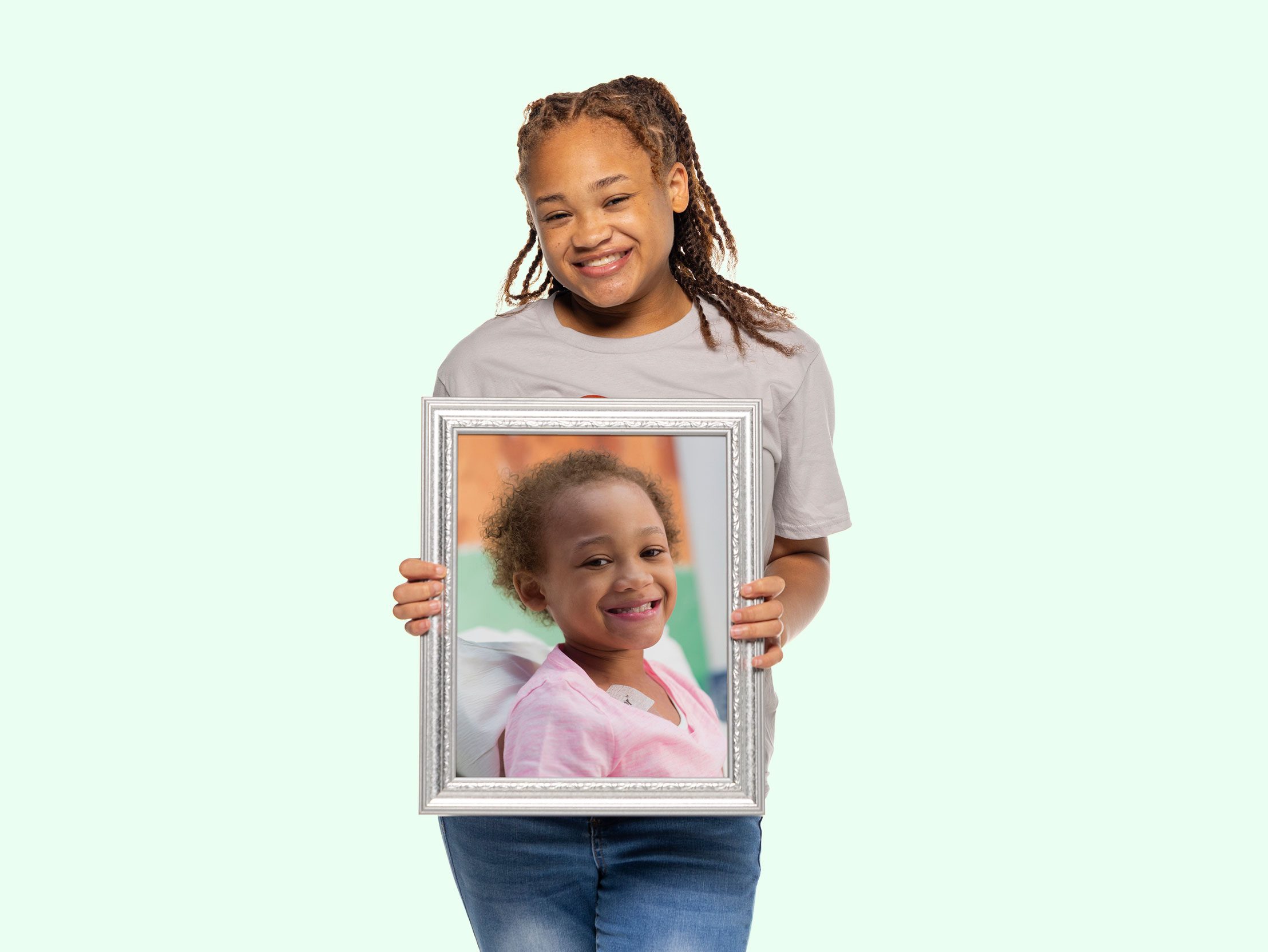 St. Jude survivor Marleigh holds a framed photo of herself from when she was undergoing treatment at St. Jude.