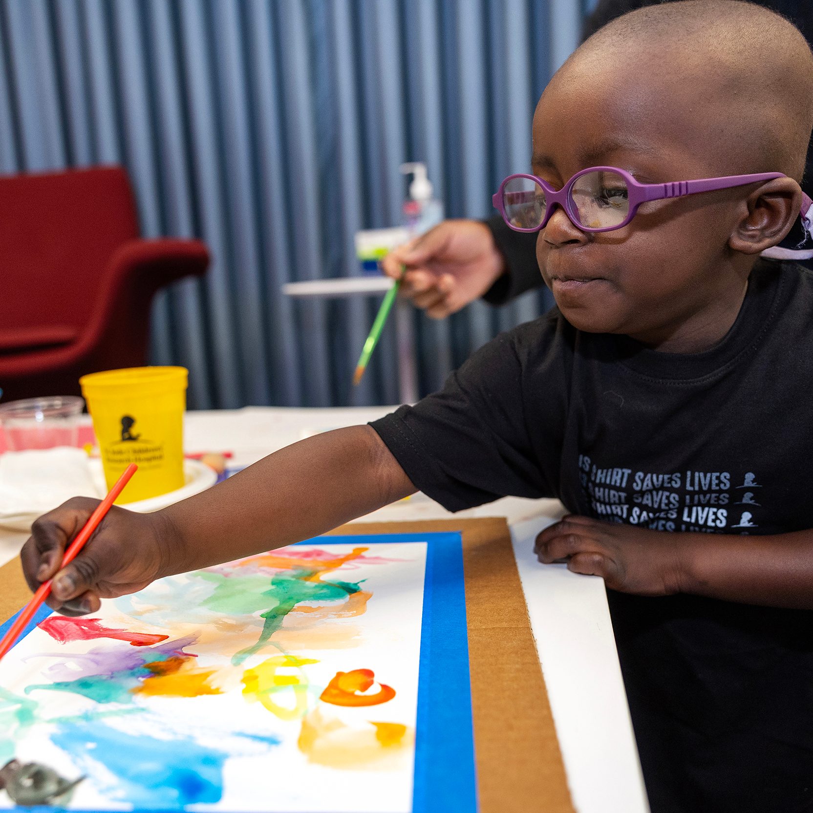 St. Jude patient Hayden paints a picture.
