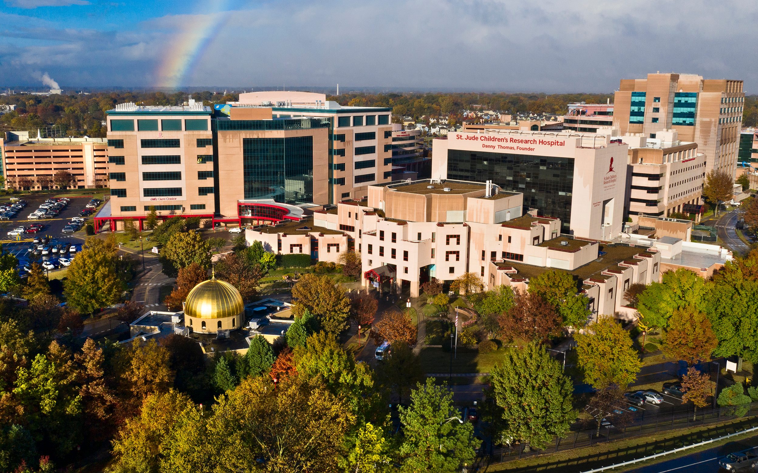 An overhead view of St. Jude Children's Research Hospital campus with a rainbow in the sky.