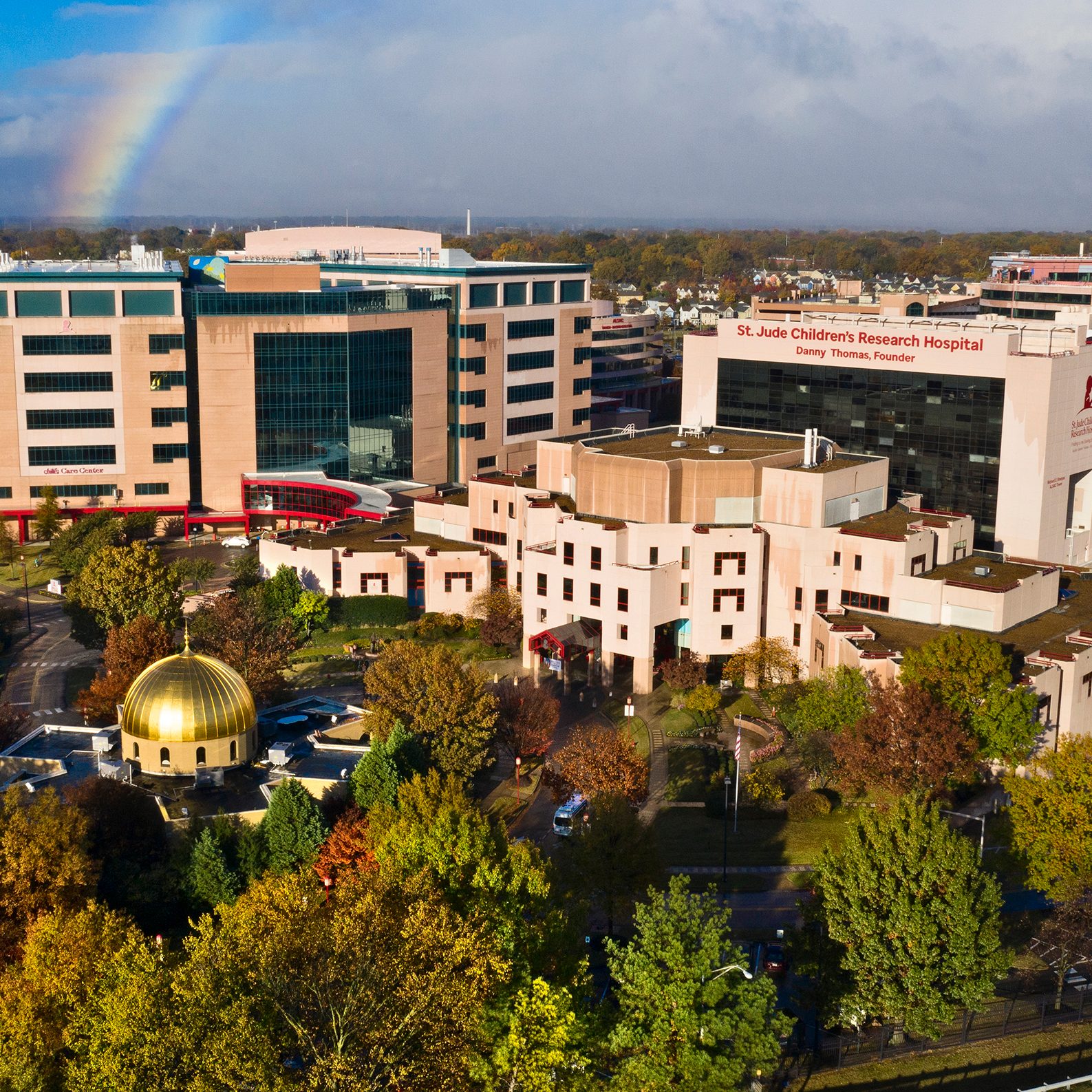 An overhead view of St. Jude Children's Research Hospital campus with a rainbow in the sky.
