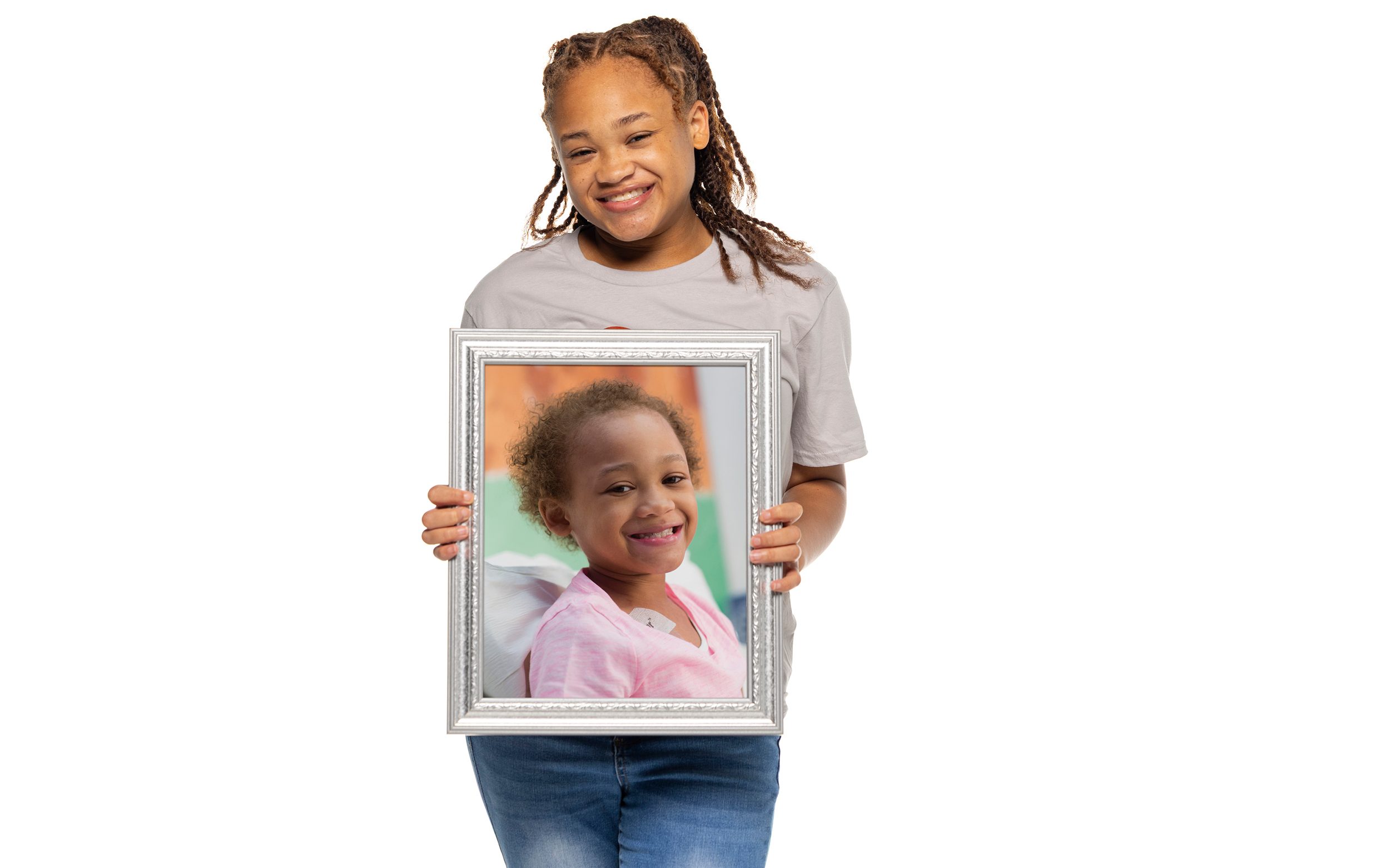 St. Jude survivor Marleigh holds a framed photo of herself from when she was undergoing treatment at St. Jude.