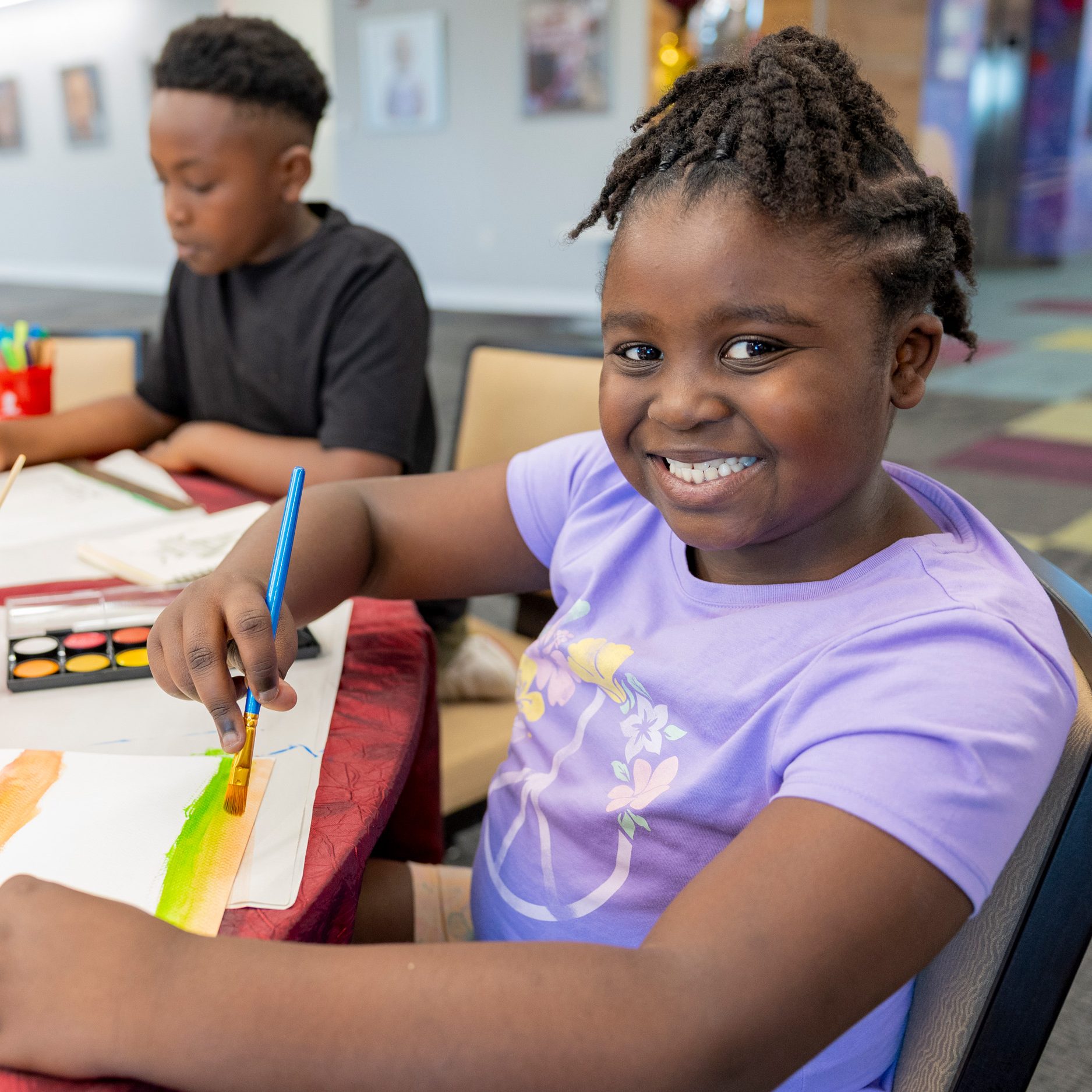 St. Jude patient Bailey painting at an art party.