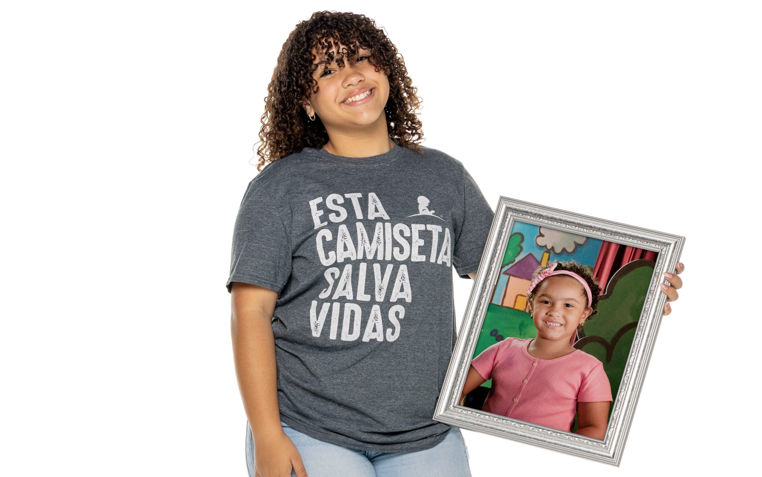 St. Jude patient Mayela holding a photo of herself as a child.