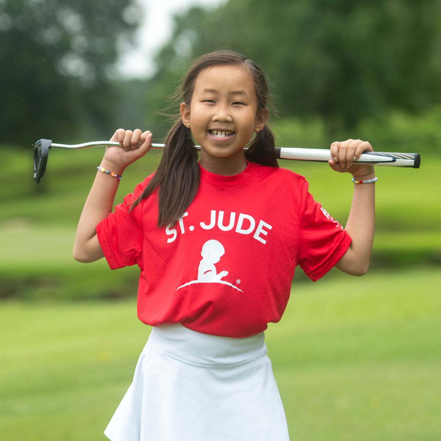 St. Jude patient Maelin posing with a putter while participating in the FedEx St. Jude Championship golf tournament.