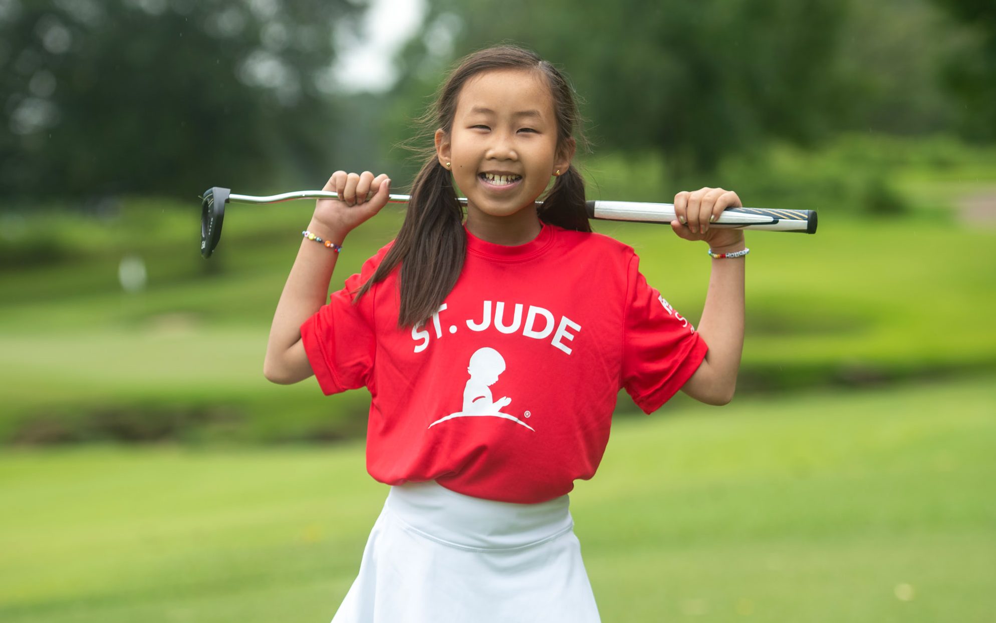 St. Jude patient Maelin posing with a putter while participating in the FedEx St. Jude Championship golf tournament.