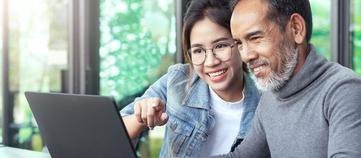 A couple happily points at a computer screen