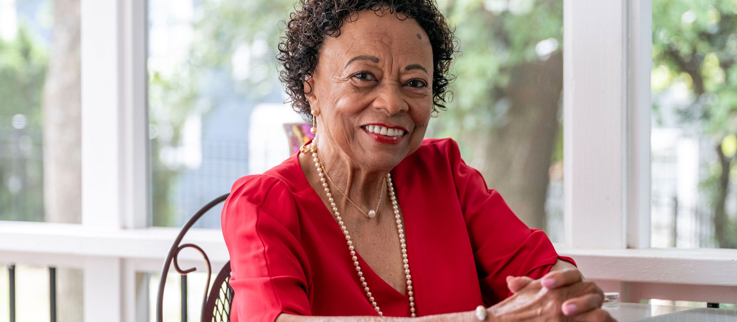A St. Jude supporter sitting in a chair with her hands folded smiling at the camera