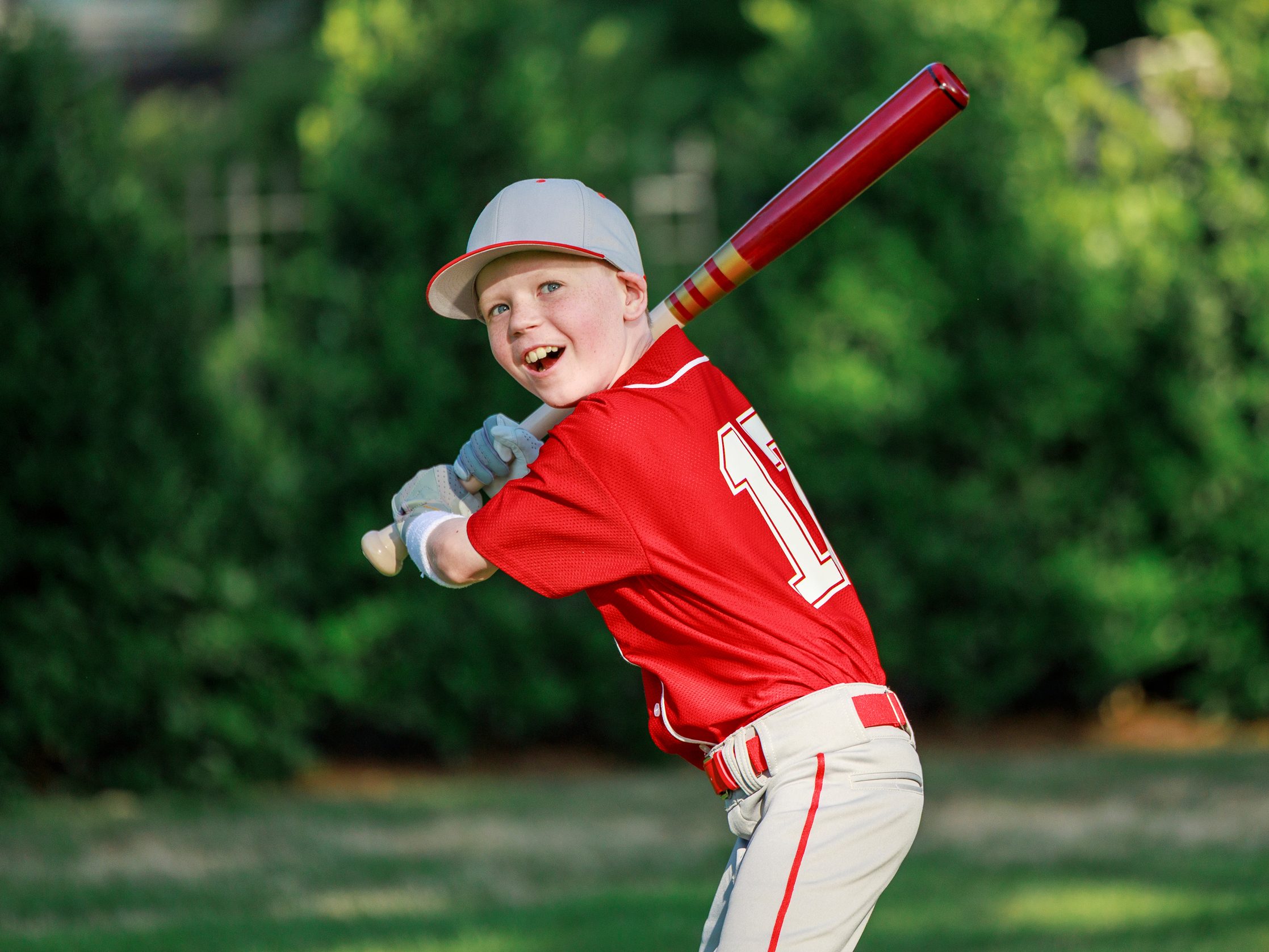 Imagen de Maddox sonriendo mientras sostiene y balancea un bate de béisbol.
