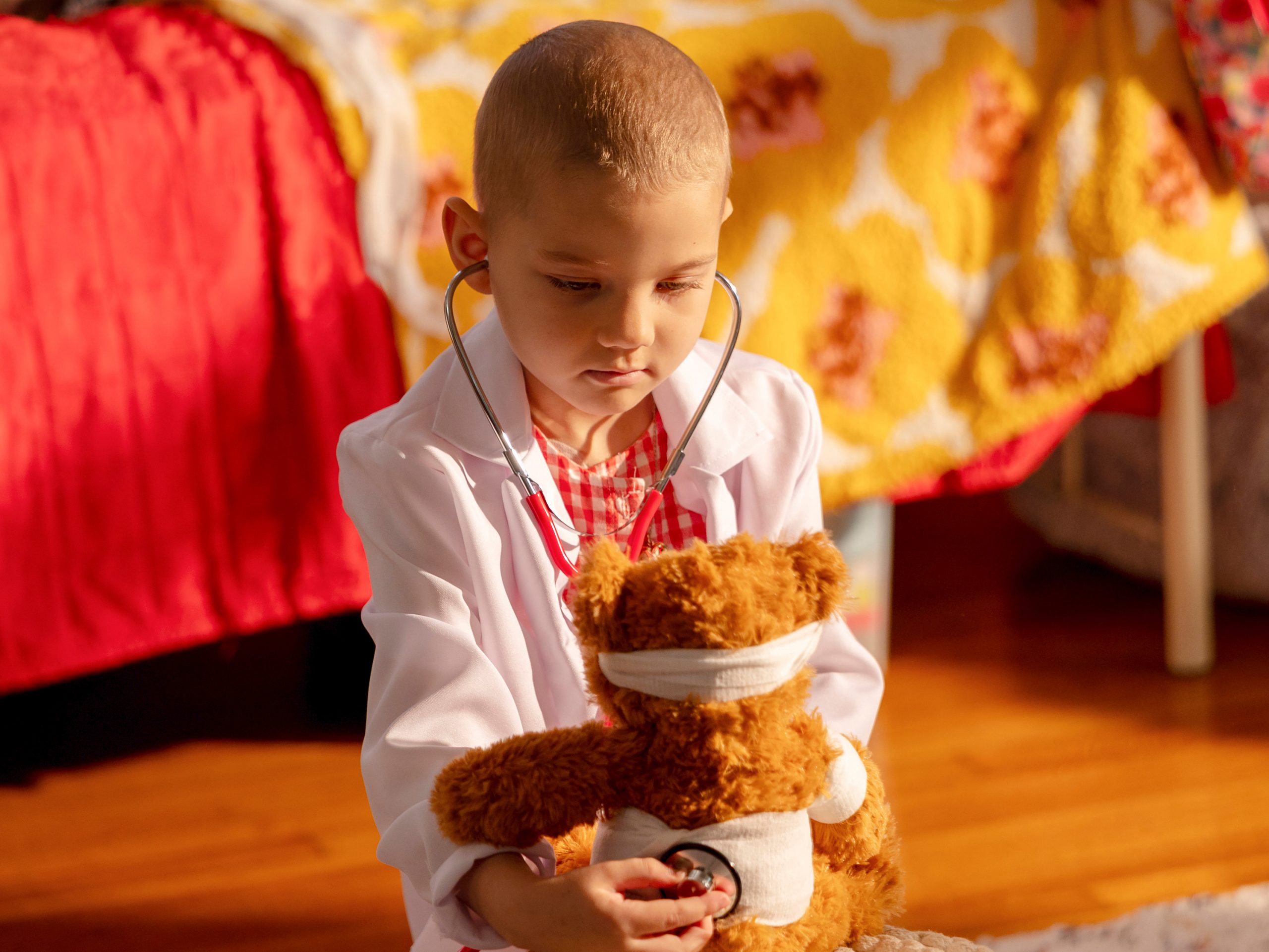Erma, paciente de St. Jude, jugando a ser doctora mientras “cura” a su osito de peluche.