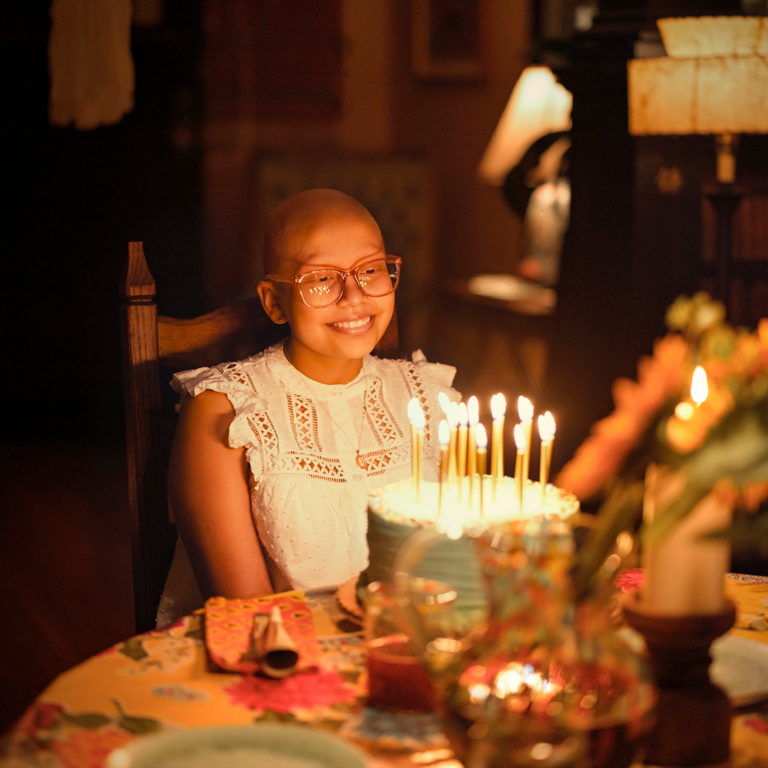 Aylin, paciente de St. Jude, frente a un pastel de cumpleaños.