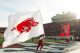 A cheerleader runs the University of Arkansas giant flag across the end zone.