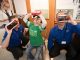St. Jude patient Warner looks through virtual reality glasses with Best Buy employees.
