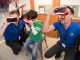 Best Buy employees and patient Warner look through virtual reality glasses.