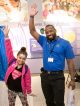 Patient Korei and Best Buy employee hold up their arms and pose for the camera.