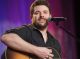 Chris Young playing guitar on stage.