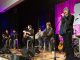 Randy Owen singing on stage with a group