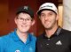 Boy posing with professional golfer