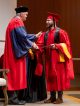 A graduating student shakes Dr. White's hand.