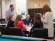 Graduate school students laugh and talk in the new graduate school activity room.