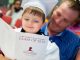 Gradiating student with man reading graduation program