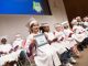 Kindergarten graduate Lilly receives her diploma.