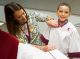 St. Jude teacher Kaci Richardson helps kindergarten graduate Andrew.