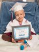 Kindergarten graduate Julia proudly displays her diploma.