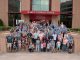 Attendees and organizers take a group photo in front of the Marlo Thomas conference center.