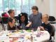 Kids work on arts and crafts at a table.