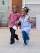 A brother and sister run around in the conference center.