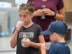 A child submits her saliva into a plastic cup for DNA analysis.