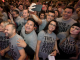 A man hold up his phone over the crowd.