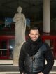 A man standing in front of the St. Jude Thaddeus statue