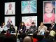 People sitting on stage and talking under large photos of St. Jude patients