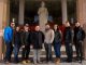 A group of people standing in front of the St. Jude Thaddeus statue