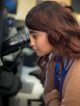 Science Scholar student looking into a microscope.