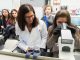 St. Jude staff assist a student in looking into a microscope during a break-out session.