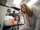 A girl looks through a microscope.