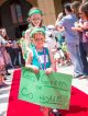 Sibling Stars walking the red carpet holding a sign that says "Go green or go home!"